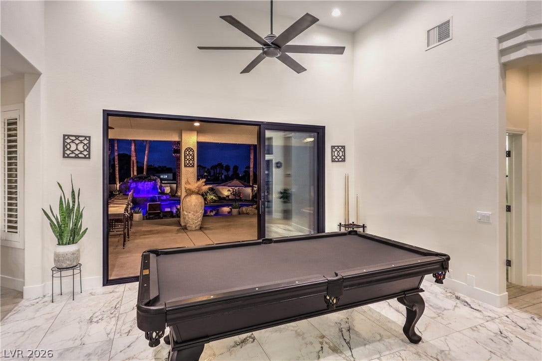 Polished tile flooring and sliding glass doors seamlessly connect this recreation space to the outdoors.