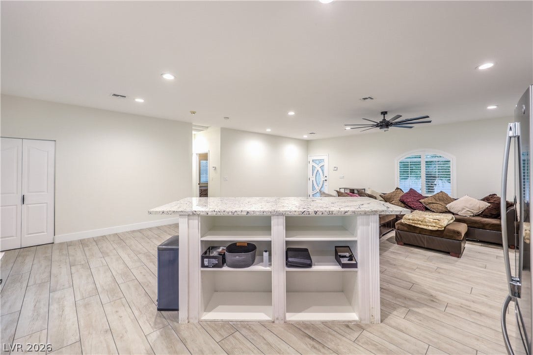 An open floorplan connects the central work island to the relaxed main living areas.