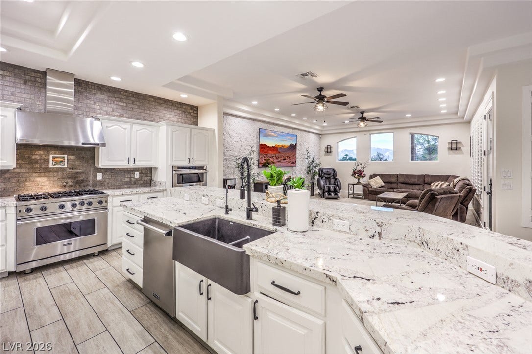 Granite counters and tile floors anchor this airy, open-concept kitchen and living area.