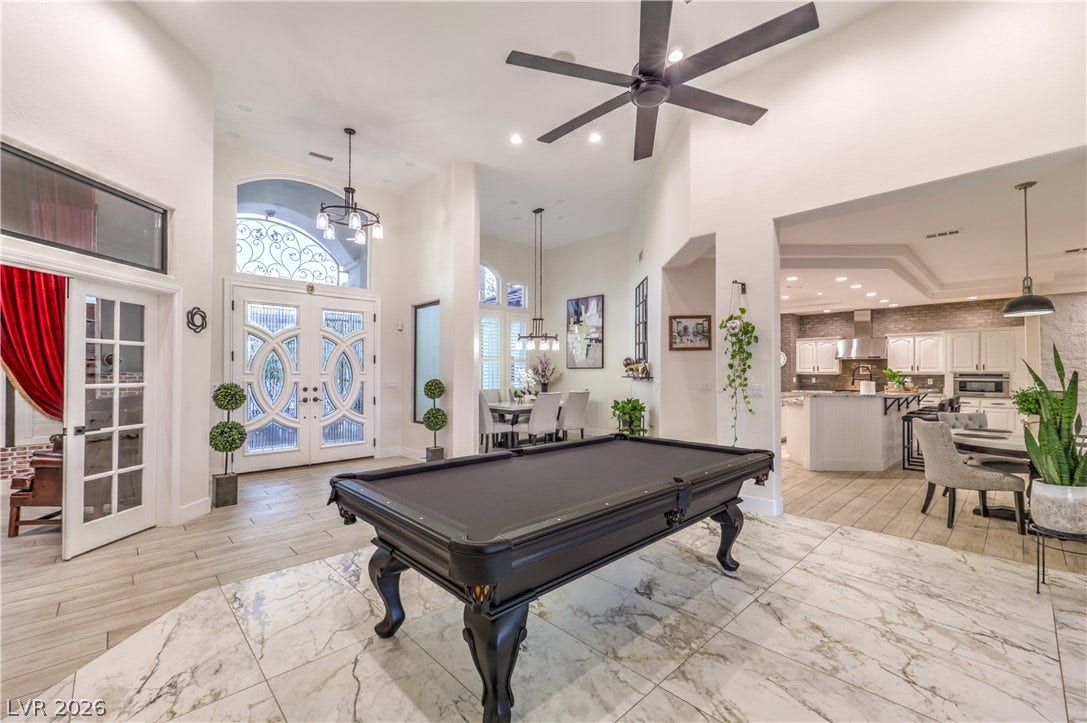 Soaring ceilings and elegant tile flooring anchor this expansive open-concept living space.