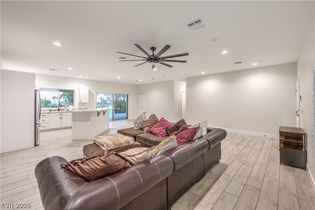 An open layout connects the spacious living area to a modern kitchen with tile floors.