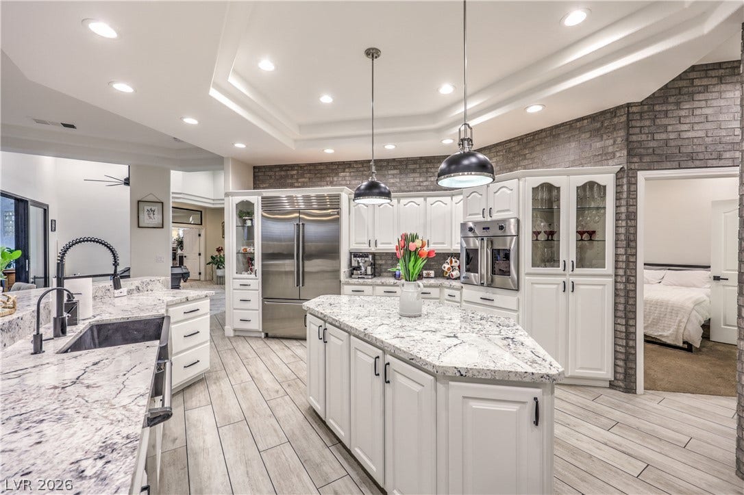 Polished stone counters, custom cabinetry, and modern appliances anchor this stylish culinary space.