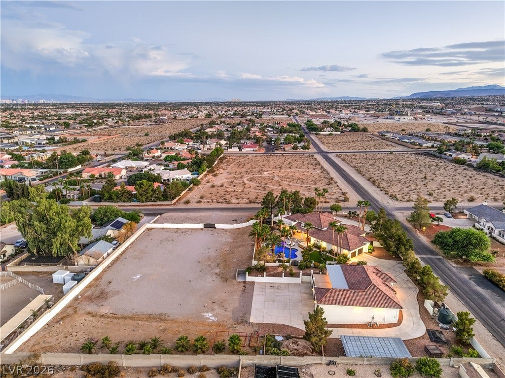 An expansive estate lot captures the surrounding desert landscape and distant mountain views.
