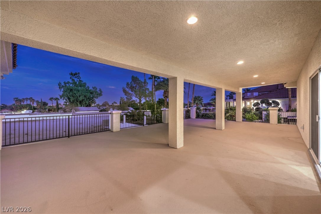 An expansive covered balcony features recessed lighting and scenic views of the surrounding neighborhood.