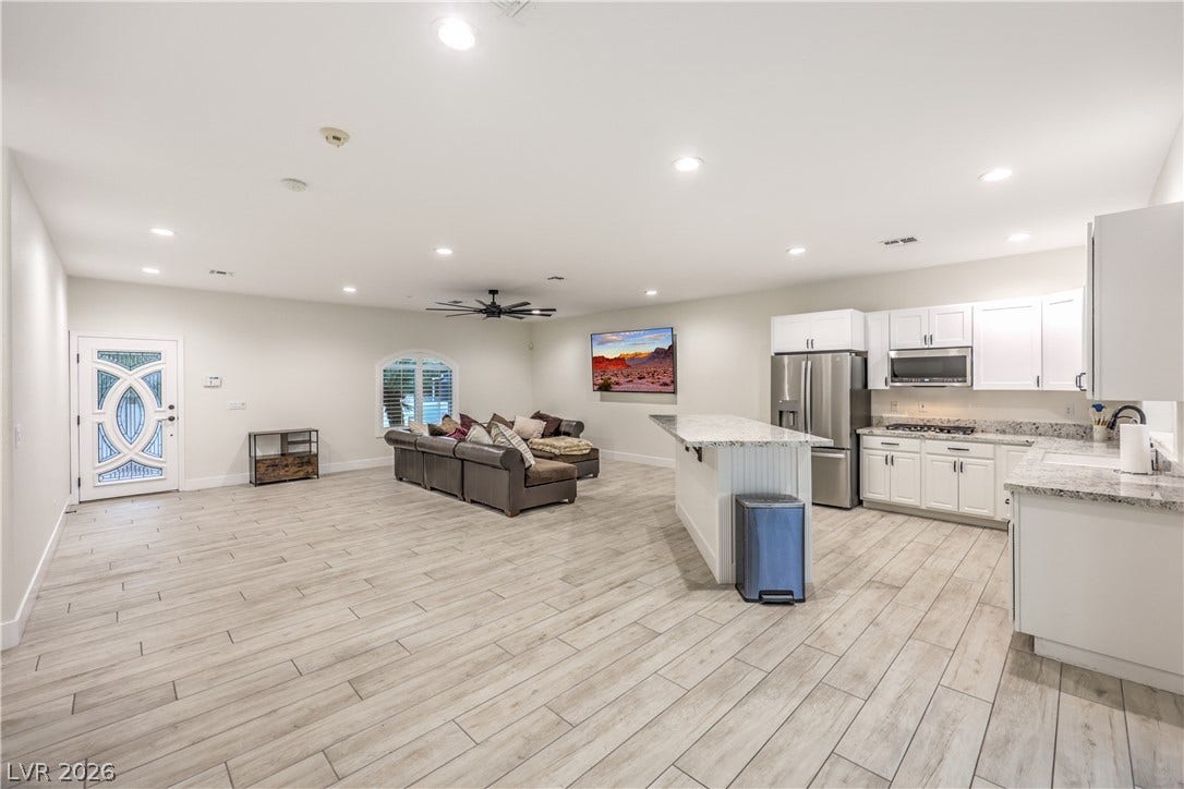An open floorplan seamlessly connects the airy living area to a modern kitchen.