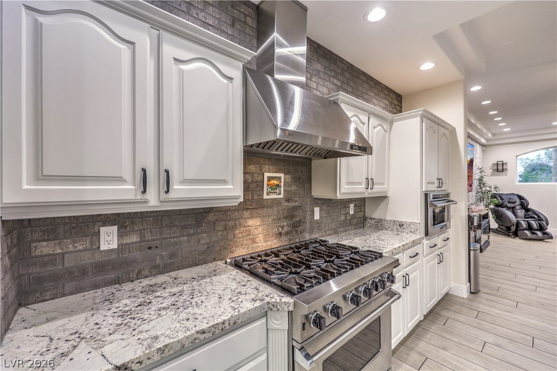 Granite countertops and a professional gas range anchor this well-appointed kitchen.