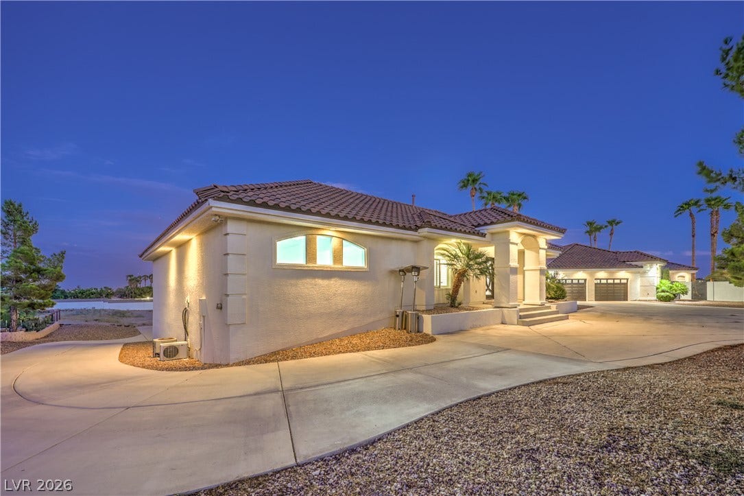 An arched window and tile roof highlight this desert home's stucco exterior.