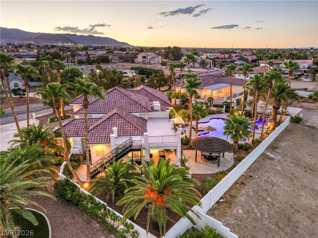 An aerial perspective showcases a tile-roofed residence alongside a private pool and mountain views.