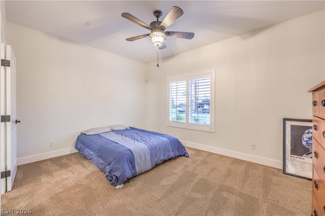 Plush carpeting and plantation shutters highlight this inviting bedroom retreat.