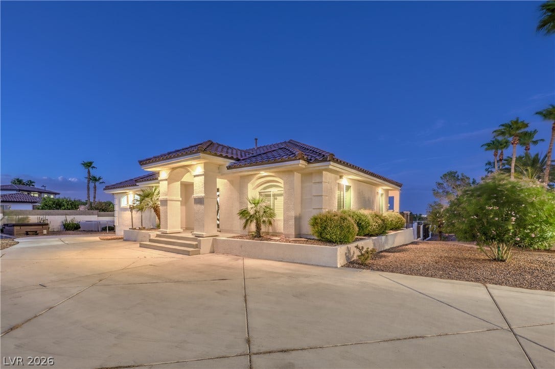 An inviting tiled-roof entryway framed by structured pillars welcomes guests under desert twilight skies.