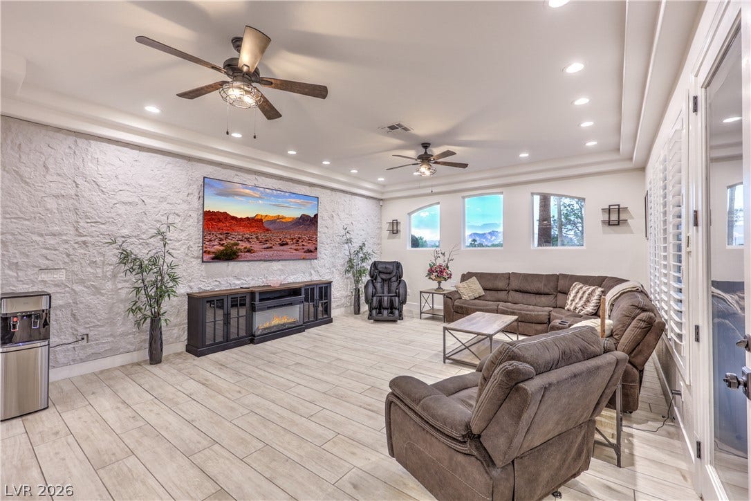 An accent stone wall complements light wood flooring in this open living space.