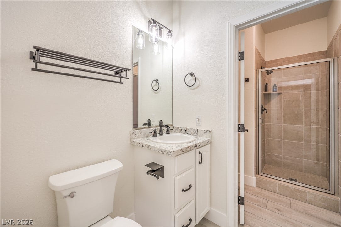 Granite counters and a walk-in tile shower elevate this guest bathroom.