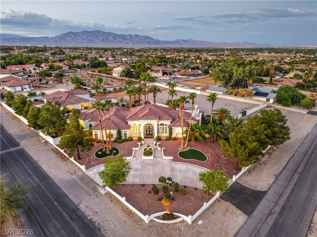 An expansive corner lot features a classic tiled roof and panoramic mountain backdrops.