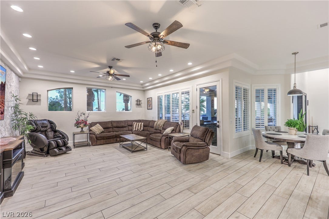 An open floor plan integrates living and dining areas over durable wood-look tile flooring.