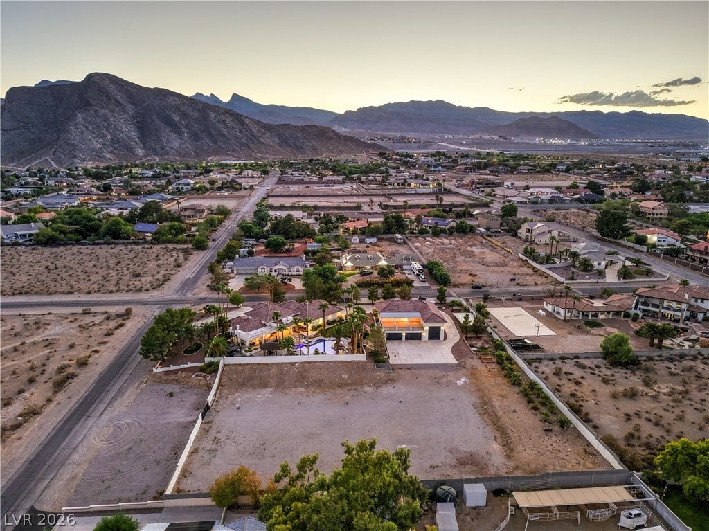 Dramatic mountain peaks frame an aerial perspective of this expansive desert estate.