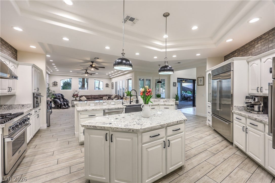 Gleaming stone countertops and a spacious central island anchor this open-concept culinary space.