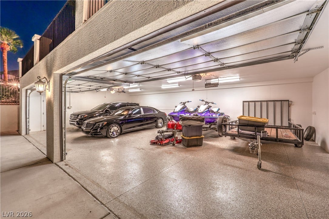 An oversized garage with protective textured flooring provides exceptional storage and utility space.