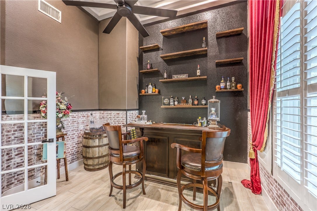A custom home bar area showcases textured brick accents and built-in shelving.