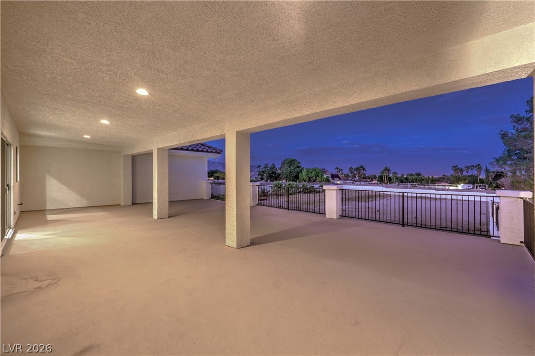 An expansive covered balcony features textured ceilings, recessed lighting, and panoramic neighborhood views.