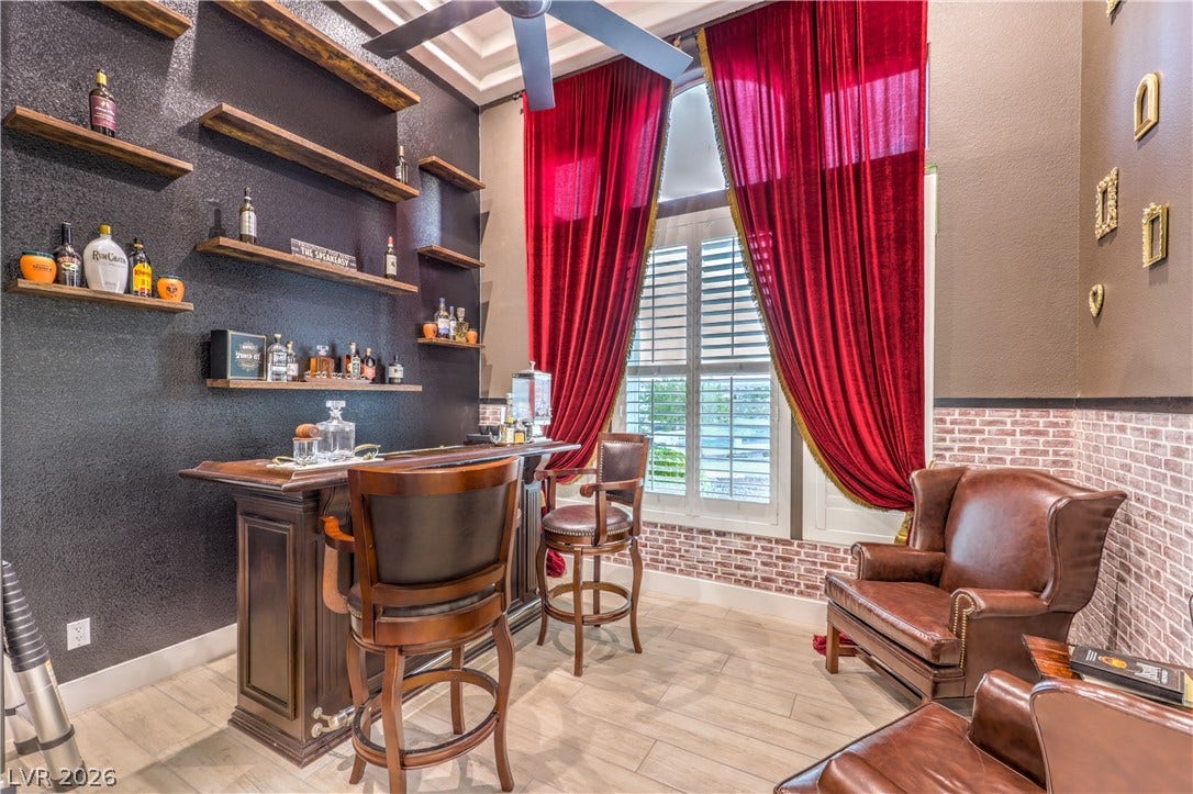 Custom wood shelving and a built-in wet bar highlight this custom entertainment space.