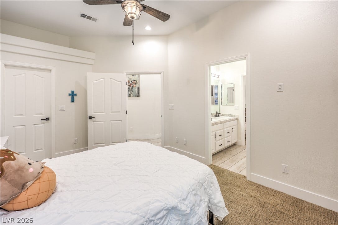 High ceilings and neutral finishes create an open feeling in this comfortable bedroom space.