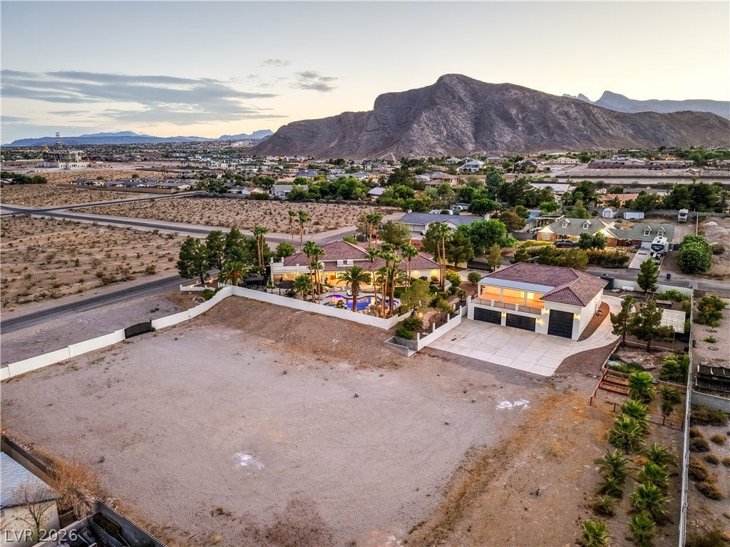 9390 Stange Avenue, Las Vegas, NV 89129 Dramatic mountain backdrops frame this sprawling desert estate with extensive paved driveways and tiled roofing.