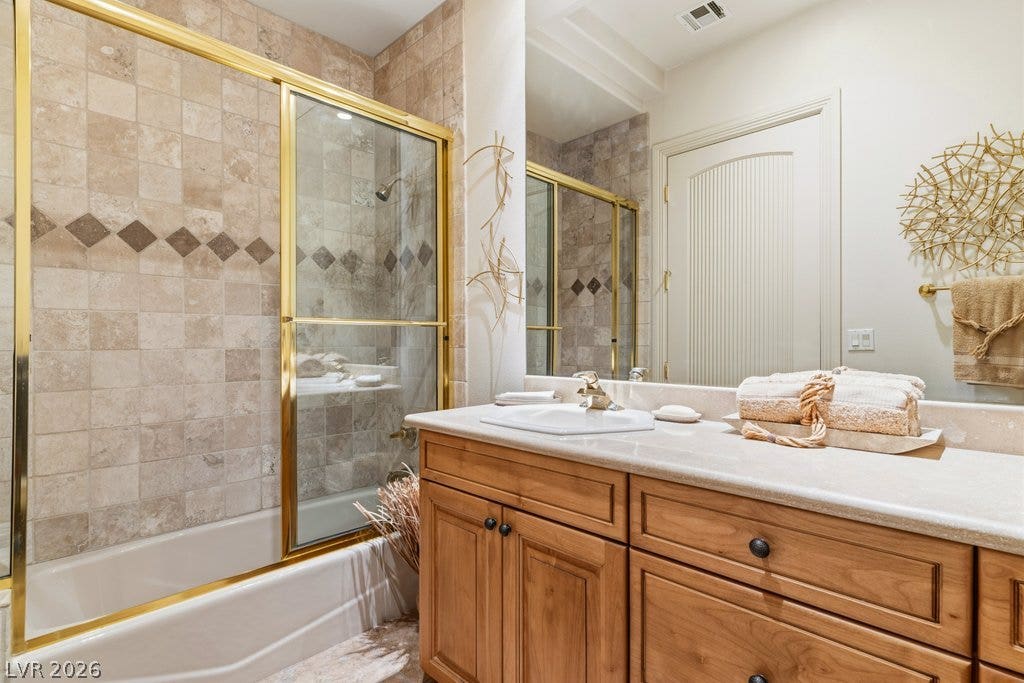 1632 Marbella Ridge Court, Las Vegas, NV 89117 Natural stone tiles and warm wood cabinetry elevate this classic bathroom design.