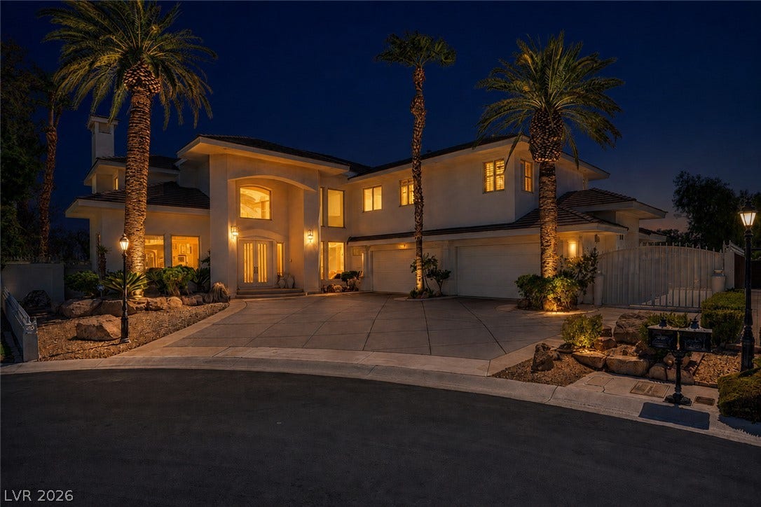 1632 Marbella Ridge Court, Las Vegas, NV 89117 Dramatic night lighting accentuates the grand entry and palm-lined driveway of this elegant estate.