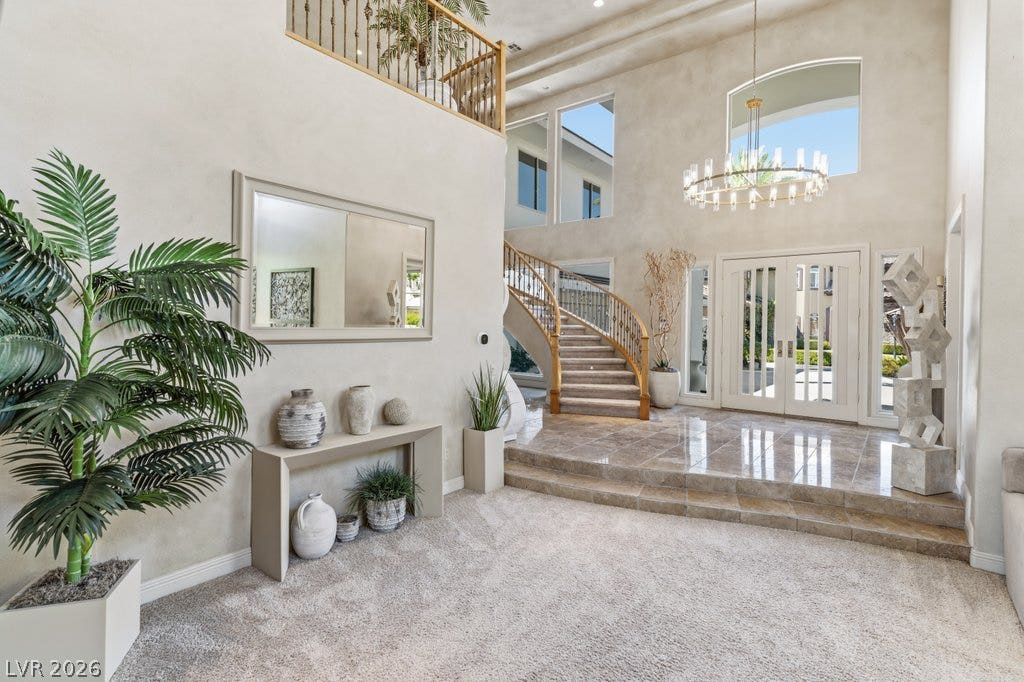 1632 Marbella Ridge Court, Las Vegas, NV 89117 Double doors open into a grand foyer featuring a curved staircase and tile flooring.