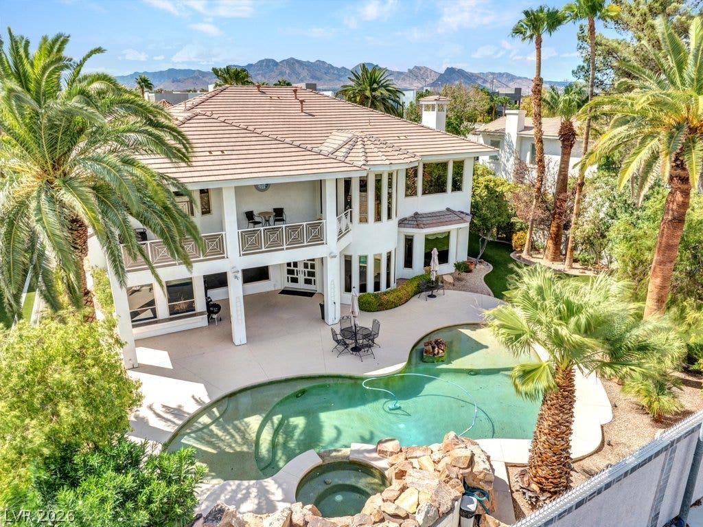 1632 Marbella Ridge Court, Las Vegas, NV 89117 A spacious backyard oasis features a freeform pool, elevated balcony, and scenic mountain views.