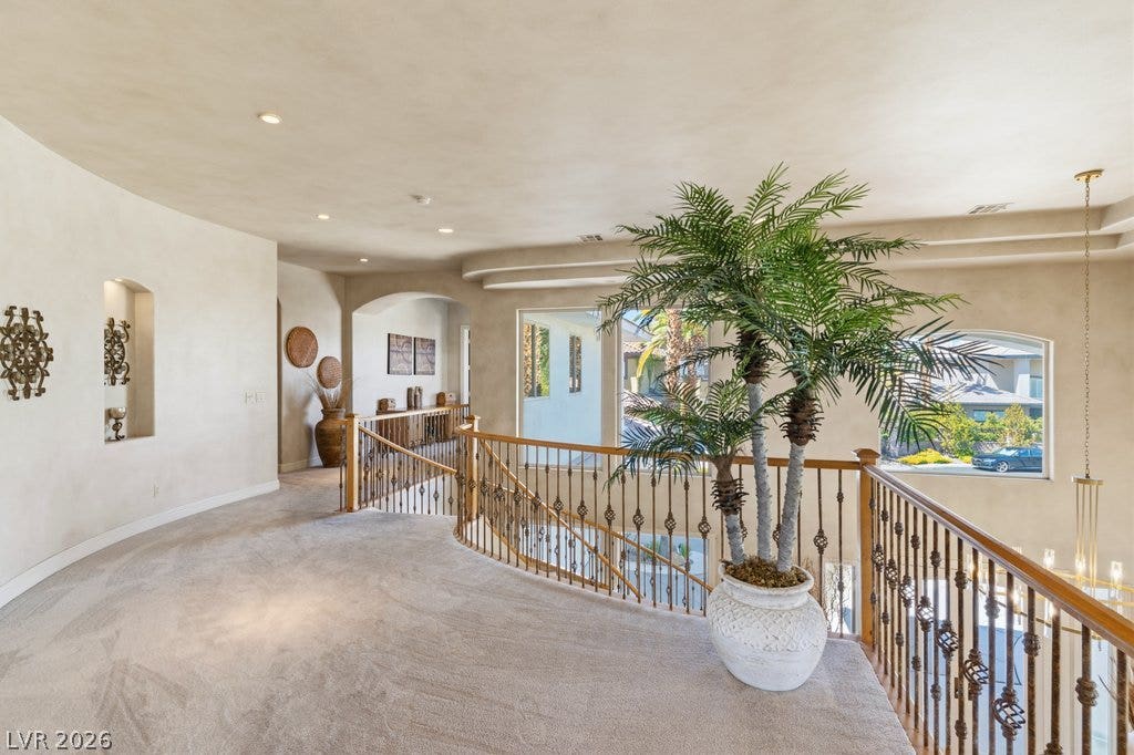 1632 Marbella Ridge Court, Las Vegas, NV 89117 An open upper hallway features plush carpeting and a curved banister overlooking the lower level.