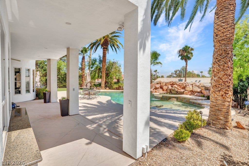 1632 Marbella Ridge Court, Las Vegas, NV 89117 Shaded concrete columns shelter a spacious outdoor patio overlooking a resort-style swimming pool.
