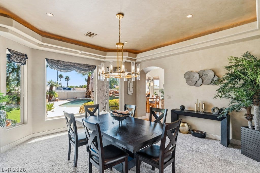 1632 Marbella Ridge Court, Las Vegas, NV 89117 An elegant dining space features a recessed tray ceiling and a large window framing pool views.