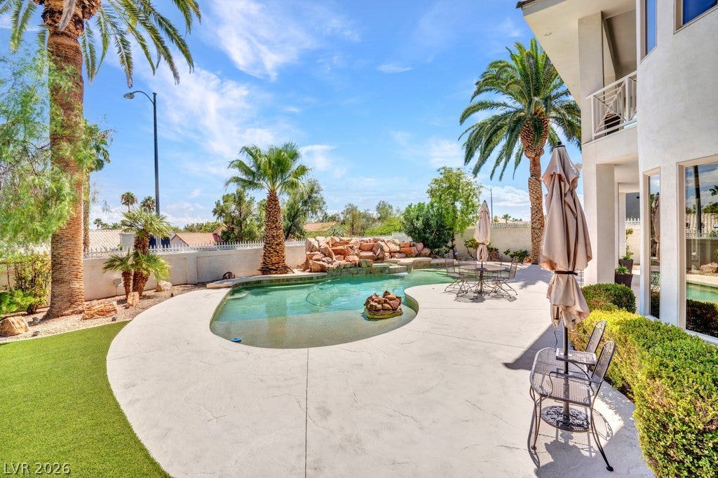 1632 Marbella Ridge Court, Las Vegas, NV 89117 Mature palms frame a custom inground pool complete with a natural rock waterfall feature.