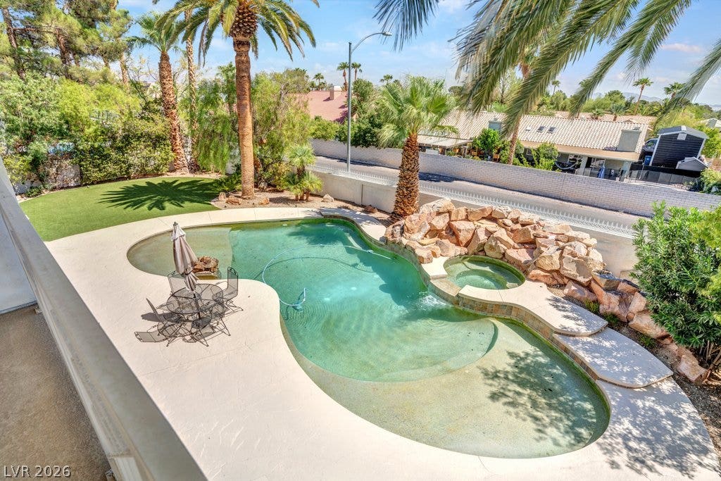 1632 Marbella Ridge Court, Las Vegas, NV 89117 Mature palms frame a private backyard oasis complete with a rock waterfall and integrated spa.