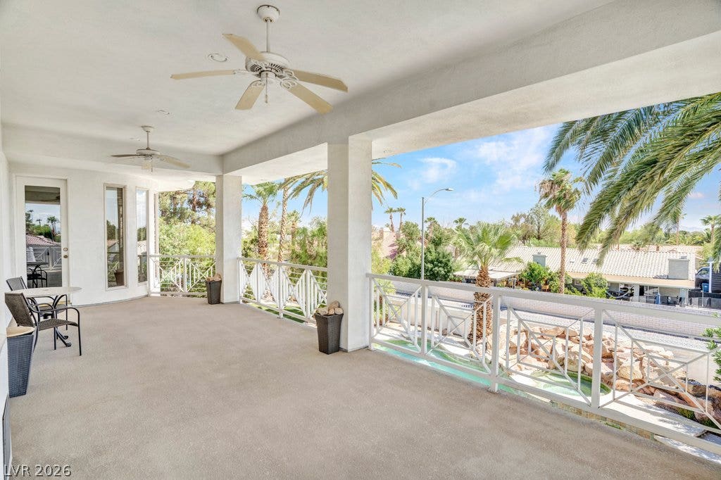 1632 Marbella Ridge Court, Las Vegas, NV 89117 A spacious covered balcony provides sweeping neighborhood views framed by palm trees and classic columns.