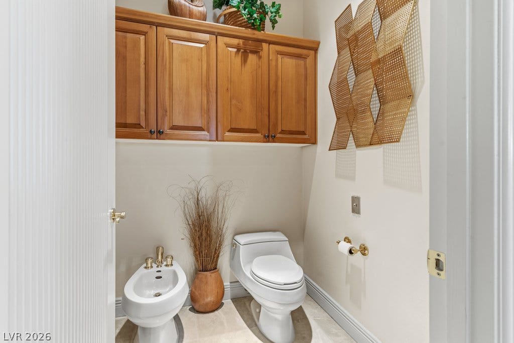 1632 Marbella Ridge Court, Las Vegas, NV 89117 Gleaming tile floors and custom wood cabinetry enhance this functional powder room space.