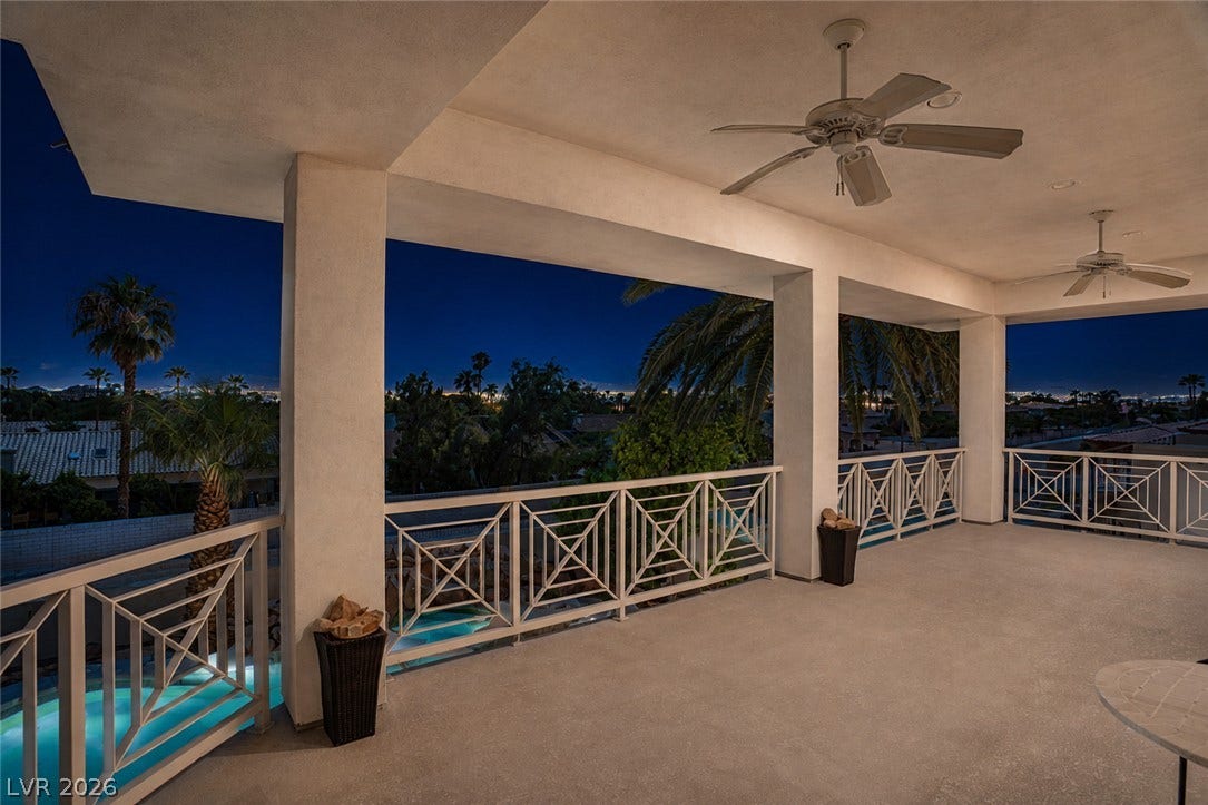 1632 Marbella Ridge Court, Las Vegas, NV 89117 An elevated terrace looks out over palm trees toward twinkling distant city lights.