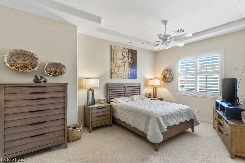 1632 Marbella Ridge Court, Las Vegas, NV 89117 Plentiful natural light fills this bedroom featuring carpet flooring and a tray ceiling detail.
