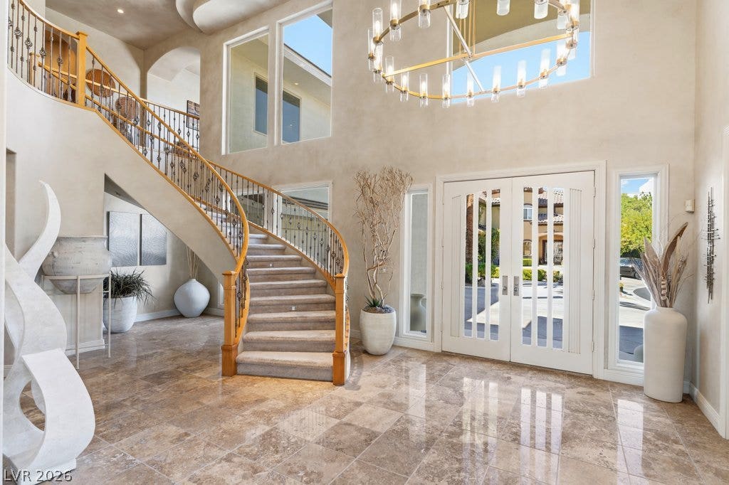 1632 Marbella Ridge Court, Las Vegas, NV 89117 Gleaming tile floors and a grand curved staircase anchor this soaring double-height entryway.