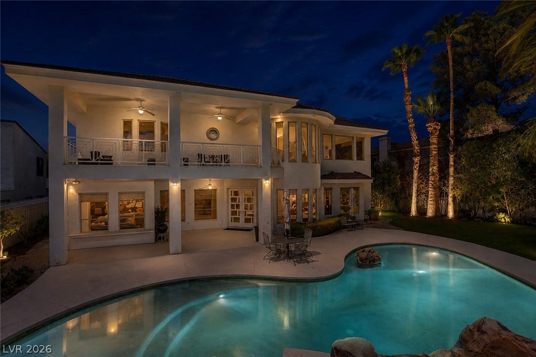 1632 Marbella Ridge Court, Las Vegas, NV 89117 An inviting backyard oasis centers around a custom swimming pool framed by mature palm trees.
