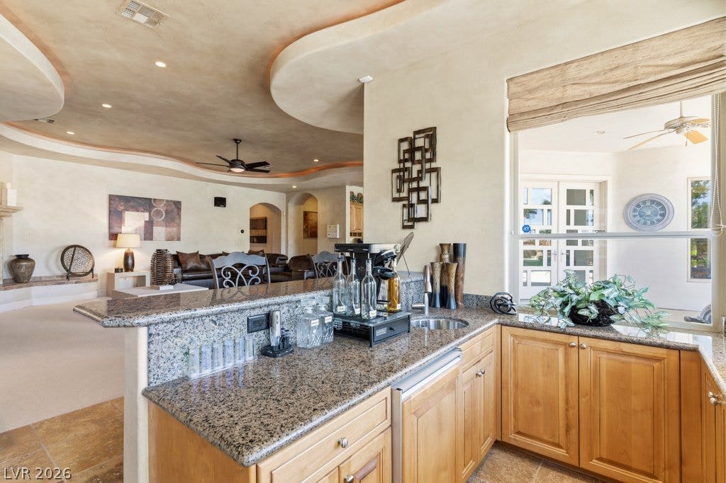 1632 Marbella Ridge Court, Las Vegas, NV 89117 Granite counters and custom cabinetry define this elevated service bar opening to the main living areas.