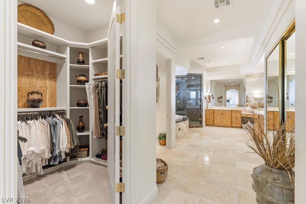 1632 Marbella Ridge Court, Las Vegas, NV 89117 A spacious walk-in closet with custom shelving opens directly to an expansive tile bathroom.