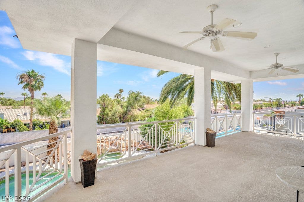 1632 Marbella Ridge Court, Las Vegas, NV 89117 An elevated, covered concrete balcony overlooks the pool area below through a geometric white railing.