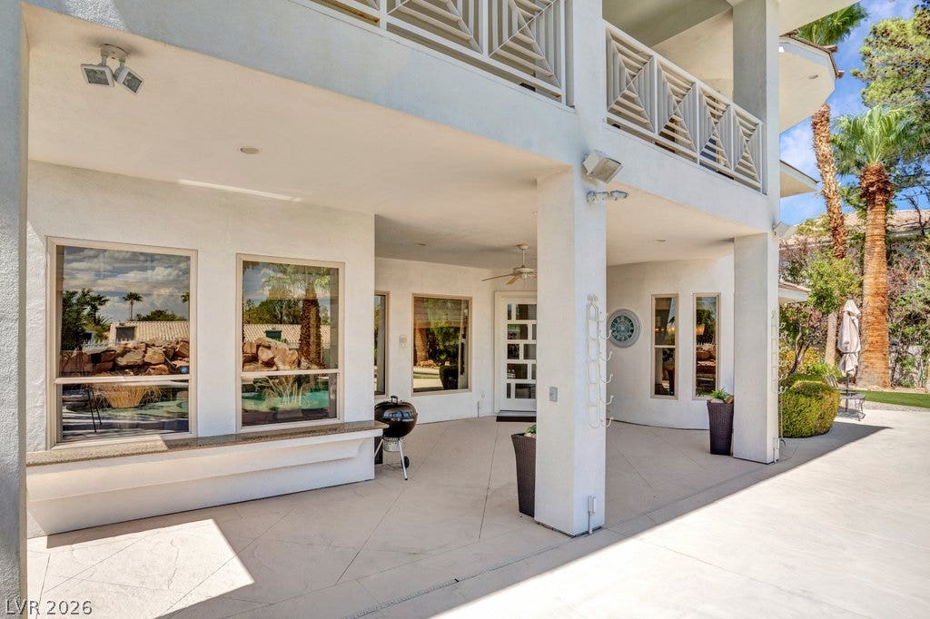 1632 Marbella Ridge Court, Las Vegas, NV 89117 Sheltered outdoor living space features textured concrete flooring and stucco pillars below an upper balcony.