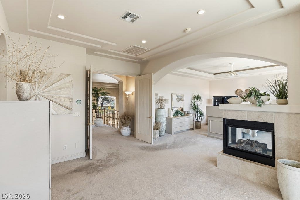 1632 Marbella Ridge Court, Las Vegas, NV 89117 An elegant double-sided fireplace anchors this open-plan layout under a tray ceiling.