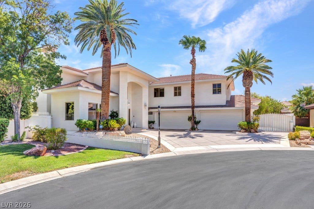 1632 Marbella Ridge Court, Las Vegas, NV 89117 Soaring palm trees frame the grand stucco facade and multi-car garage of this elegant residence.