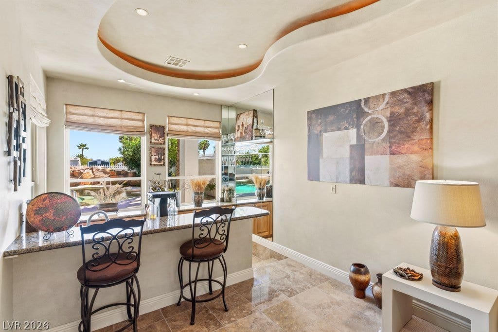1632 Marbella Ridge Court, Las Vegas, NV 89117 A custom tray ceiling crowns this sleek wet bar complete with elegant tile flooring.