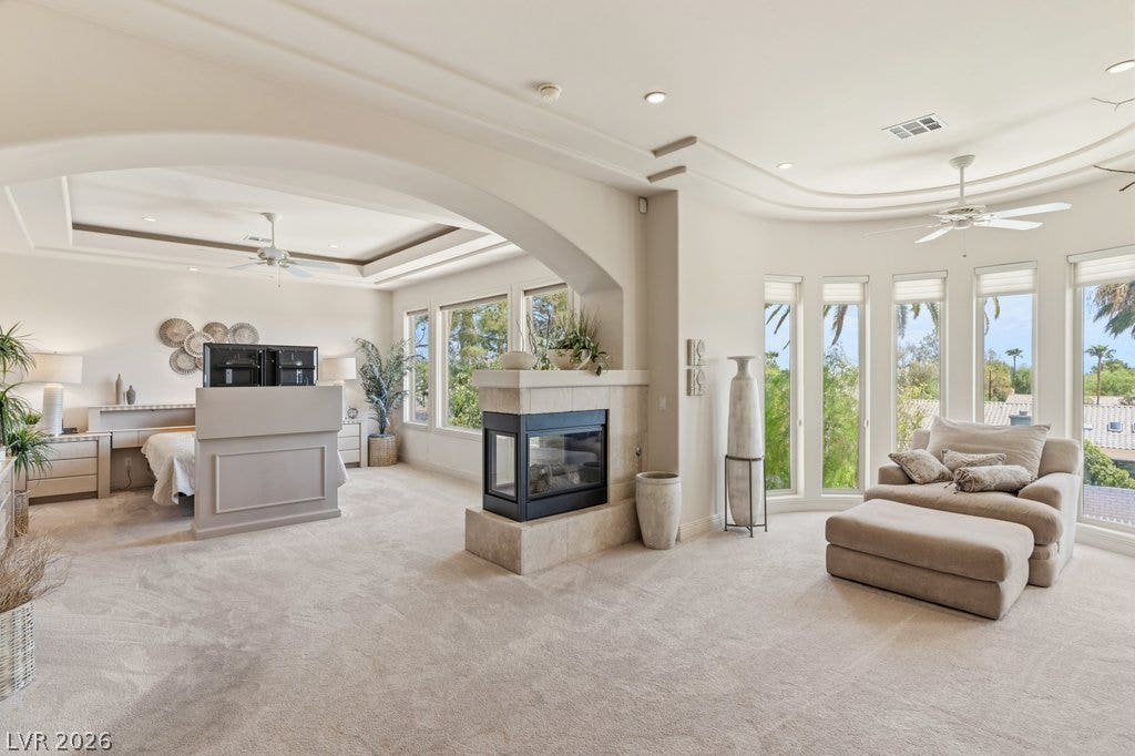 1632 Marbella Ridge Court, Las Vegas, NV 89117 An open archway links the sleeping space to a relaxing sitting area with a fireplace.