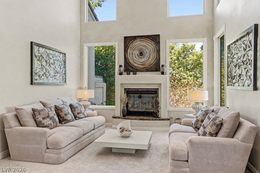1632 Marbella Ridge Court, Las Vegas, NV 89117 Towering ceilings and a central fireplace create a dramatic focal point in this room.